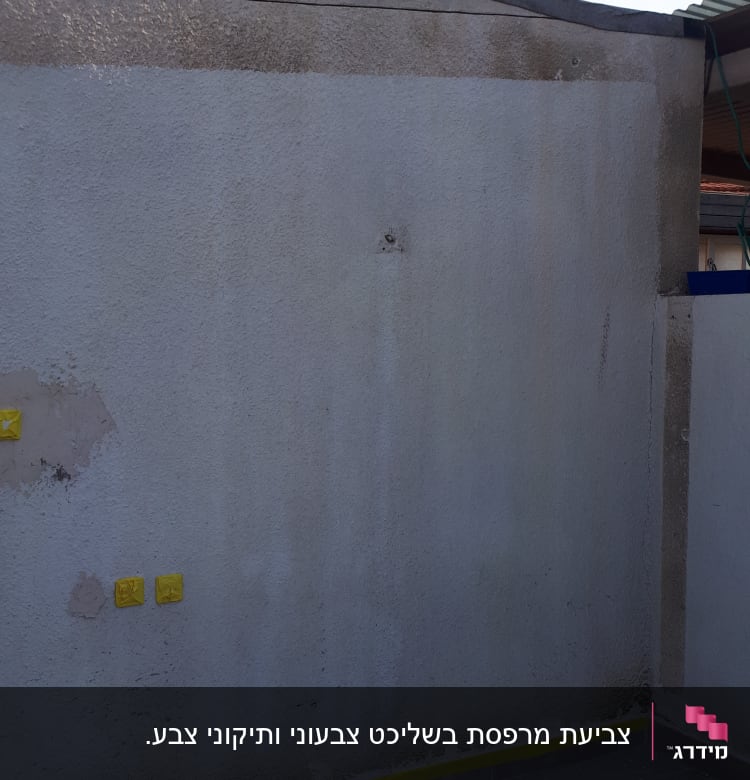 קיר עם סימני תיקון, סרט דבק צהוב, מגש צבע